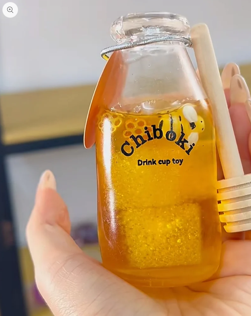 Honey yellow glitter drink bottle squishy toy with a bee charm
